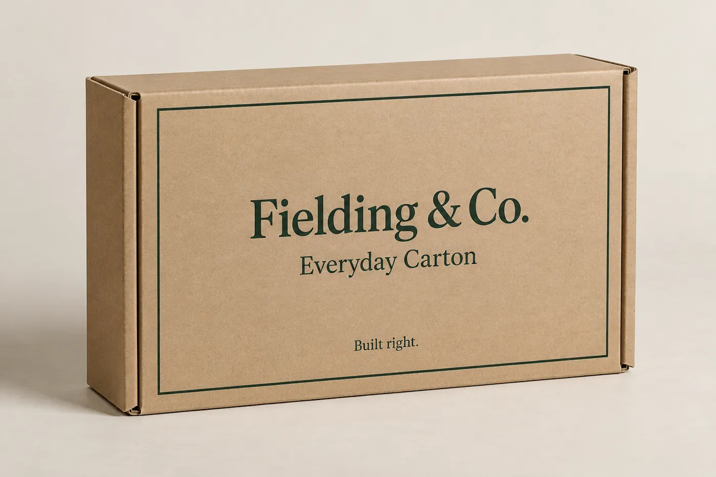 Closed kraft cardboard mailer box with forest-green border print and Fielding & Co. branding
