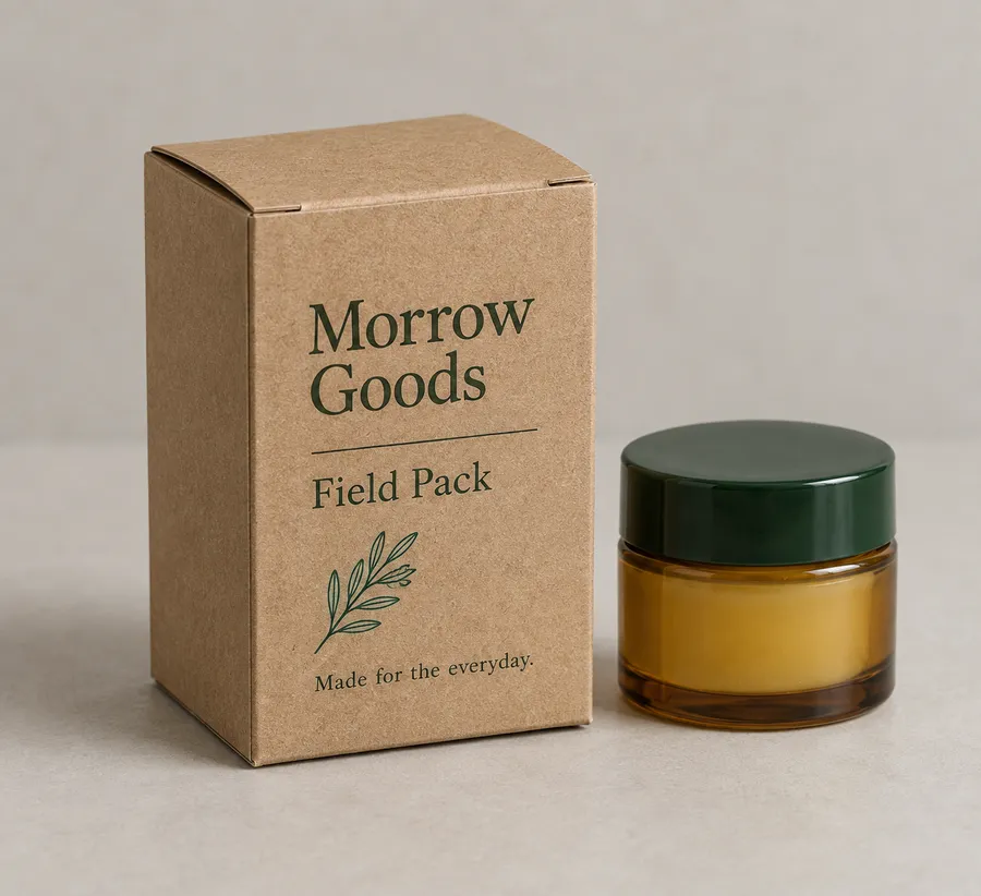 Brown kraft tuck-top box with green print beside an amber botanical balm jar
