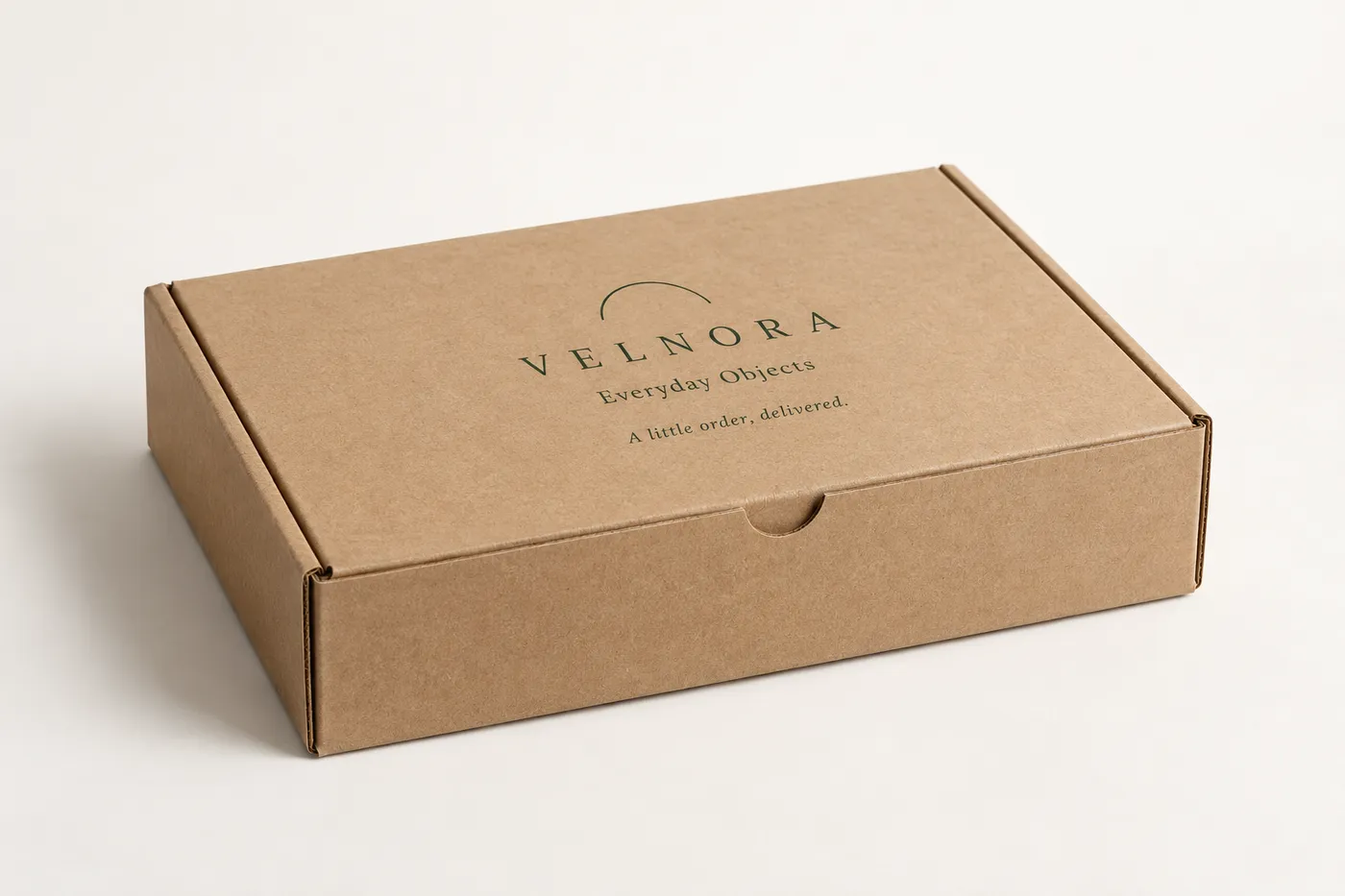 Closed kraft mailer with forest green VELNORA artwork printed on the lid.